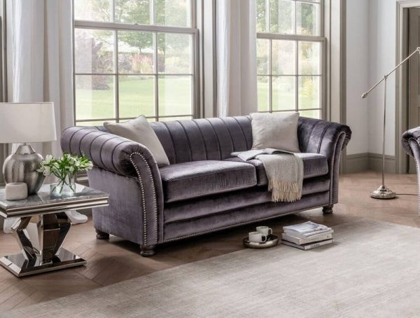 Luxurious Grey giselle 3 seater sofa with silver studding on a carpet