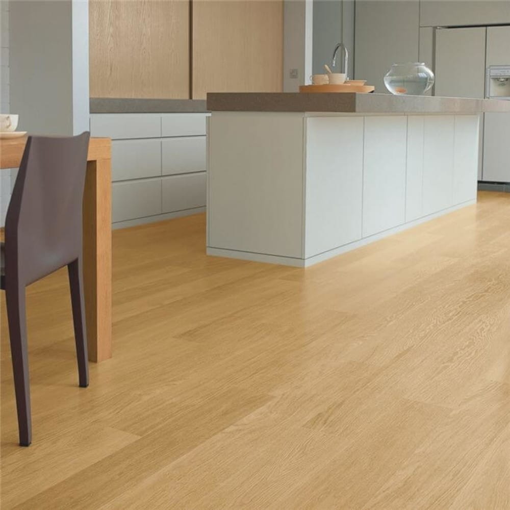 Natural varnished oak quickstep wood floors with a dining table in the corner