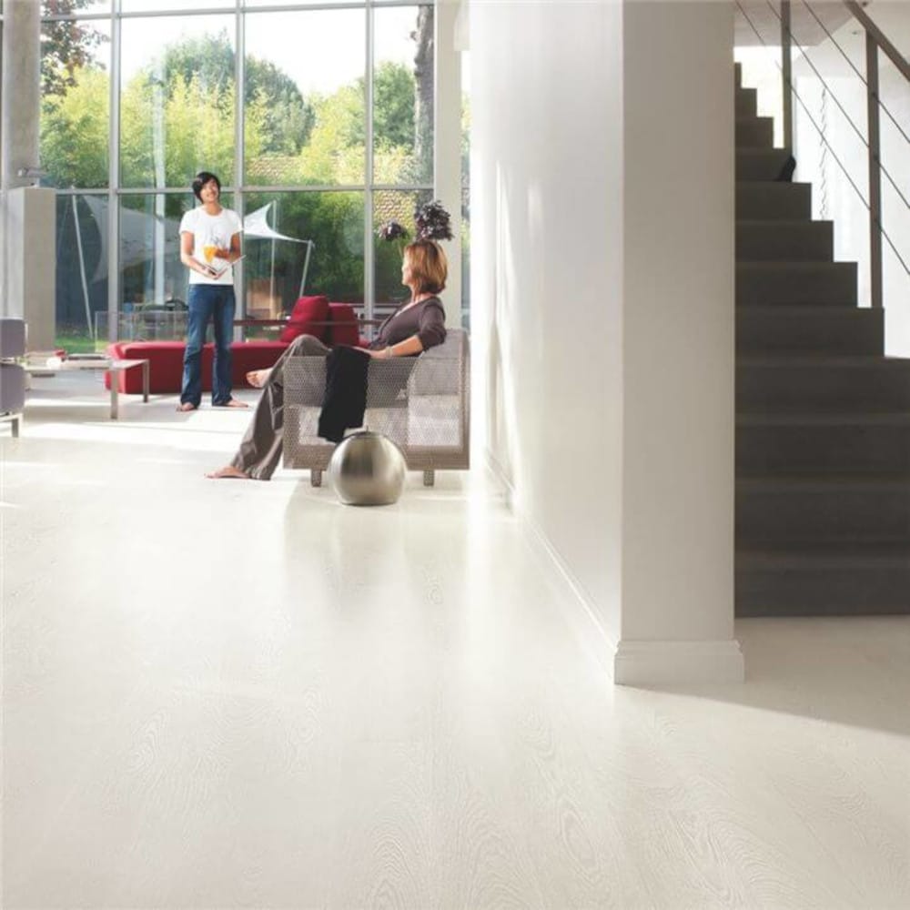 White quickstep wood flooring with stairs and carpet in the back
