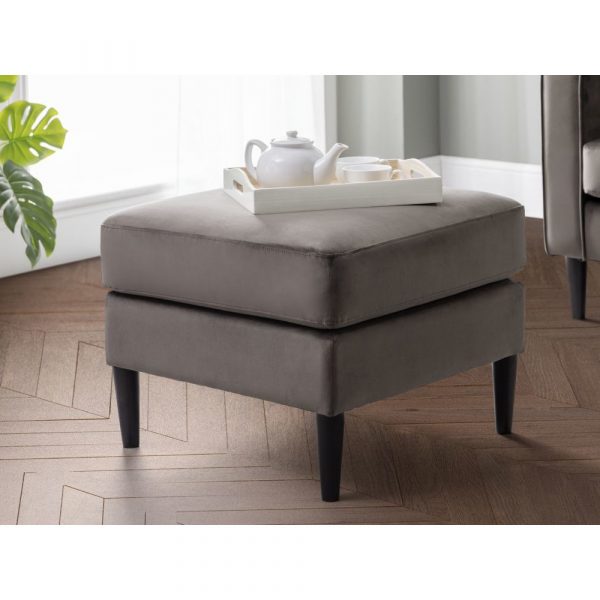 Grey ottoman foot stool in the middle of a living room